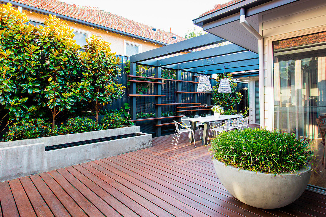Modern back yard with terrace and seating under the pergola