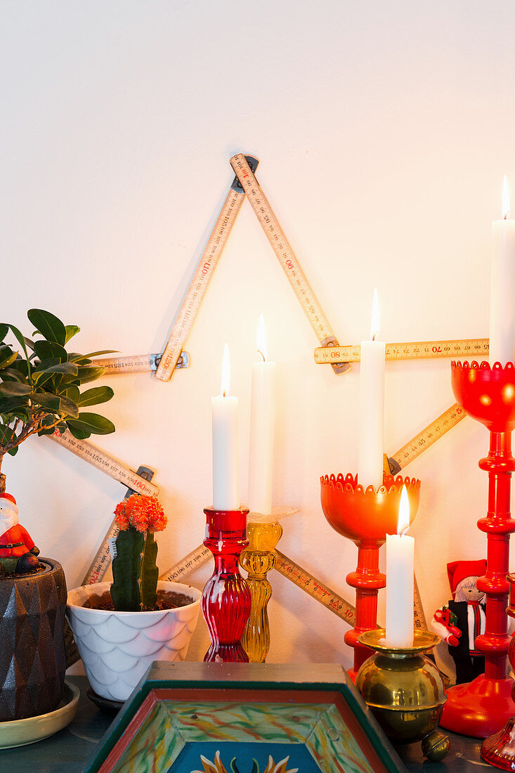 Stern aus Meterstab und brennende Kerzen als Weihnachtsdekoration
