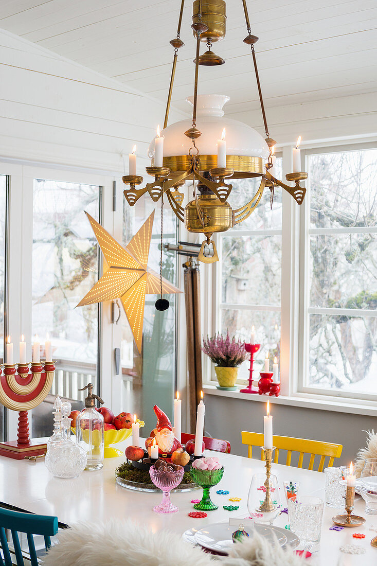 Weihnachtlich dekorierter Esstisch in skandinavischem Wintergarten
