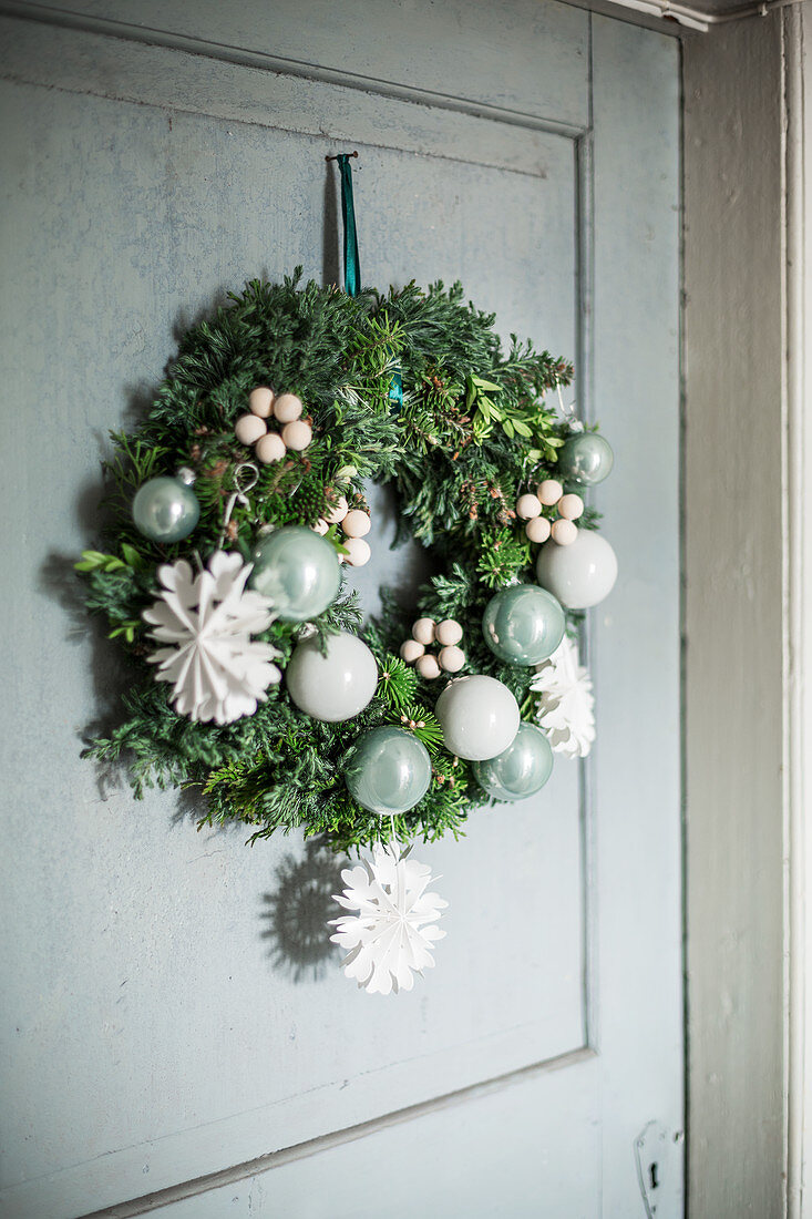 Festive door wreath with paper snowflakes and baubles
