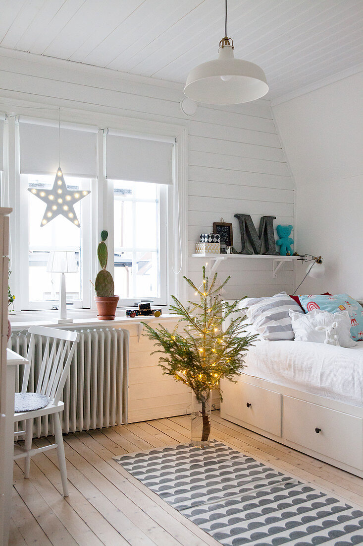 Teenager's bedroom with white wood cladding decorated for Christmas