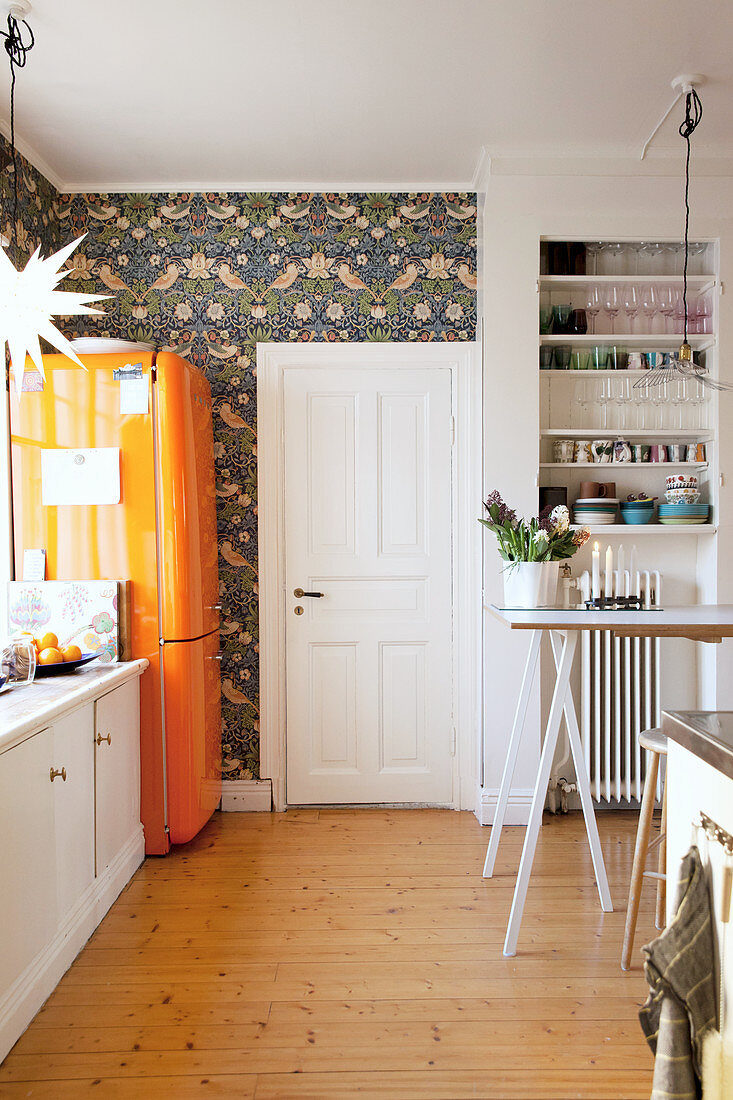 White base cabinets, orange fridge and Christmas decorations in kitchen