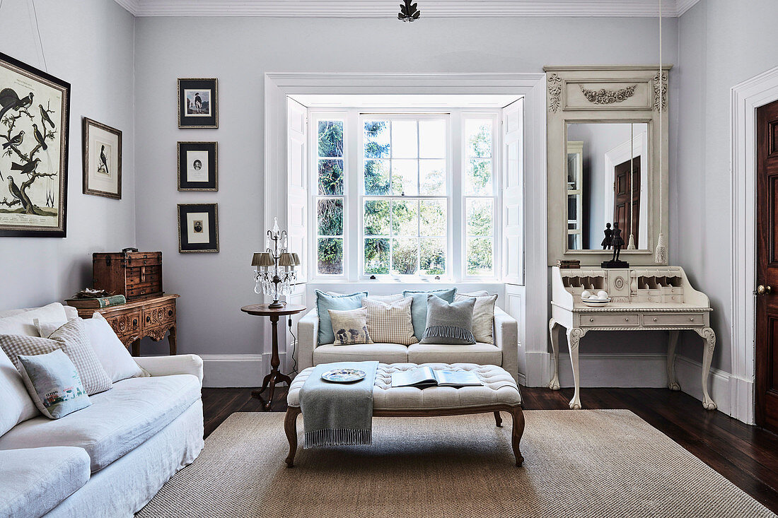 Classic living room with sofa in the bay window and antique secretary
