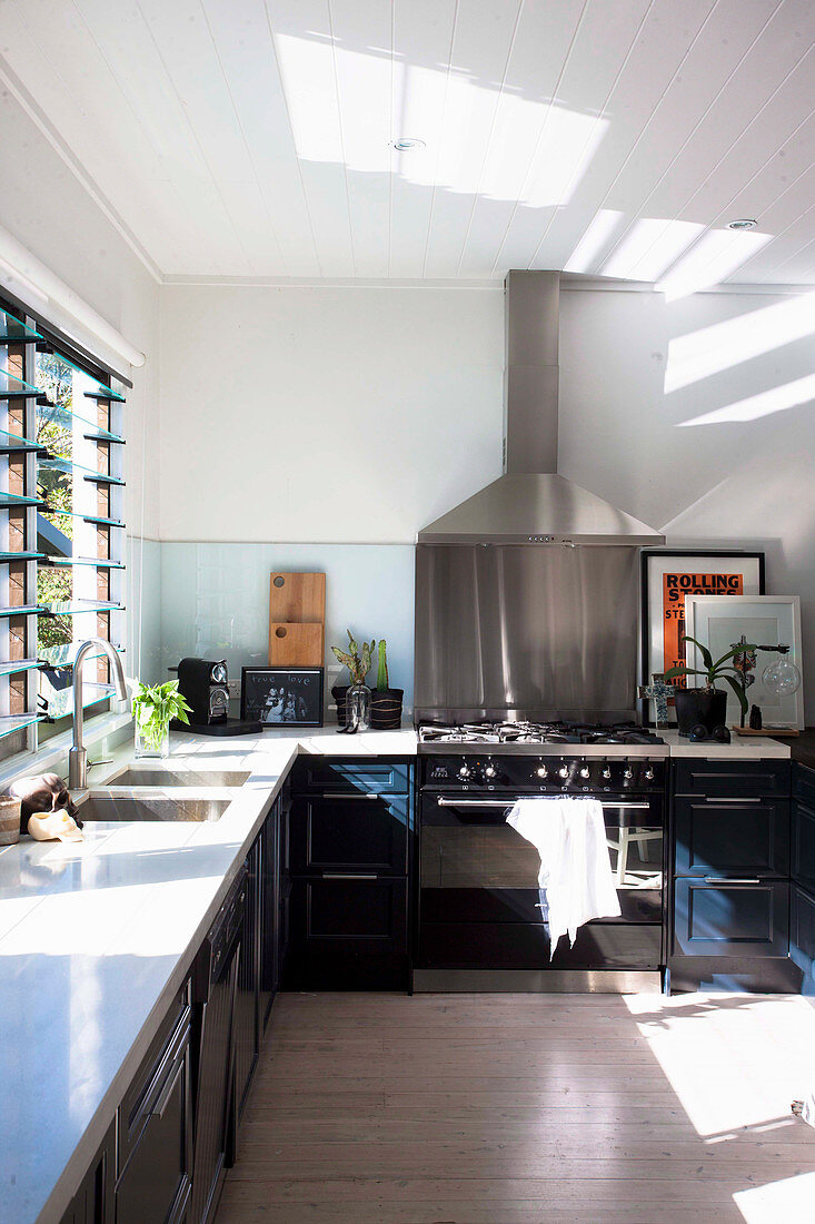 L-förmige Küche mit Lichteinfall durch Lamellenfenster