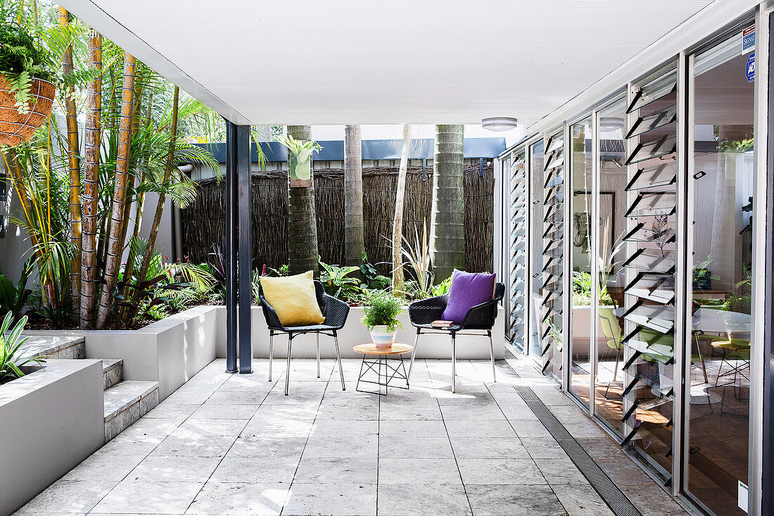 Zwei Stühle und Beistelltisch auf überdachter Terrasse