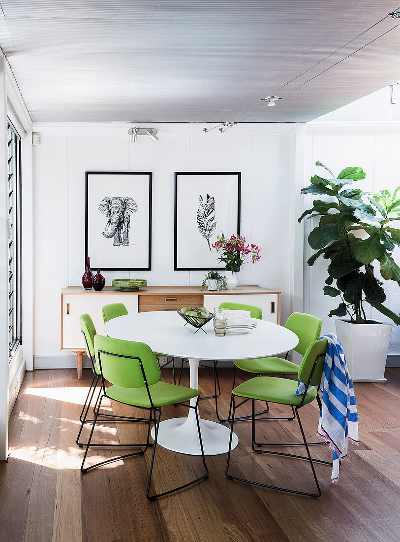 Replica of a classic table with lime green chairs in an open dining area