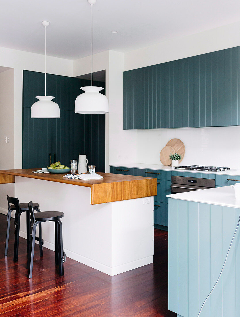 Einbauküche mit blau-grau lackierter Holzfront und Kücheninsel