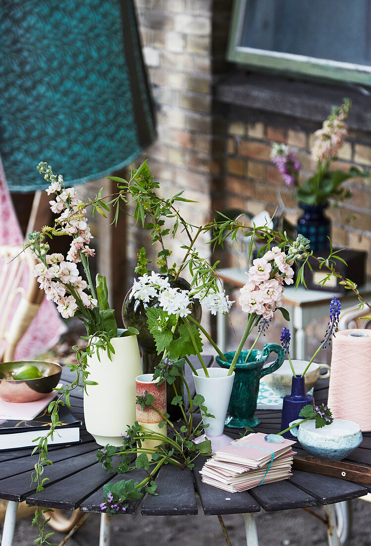 Blumendeko im Boho-Stil in verschiedenen Vasen auf dem Tisch