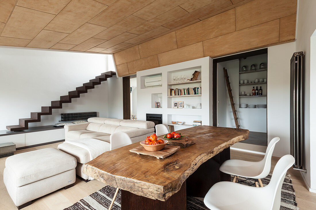 Rustikaler Holztisch mit Klassikerstühlen und Sofagarnitur in offenem Wohnraum
