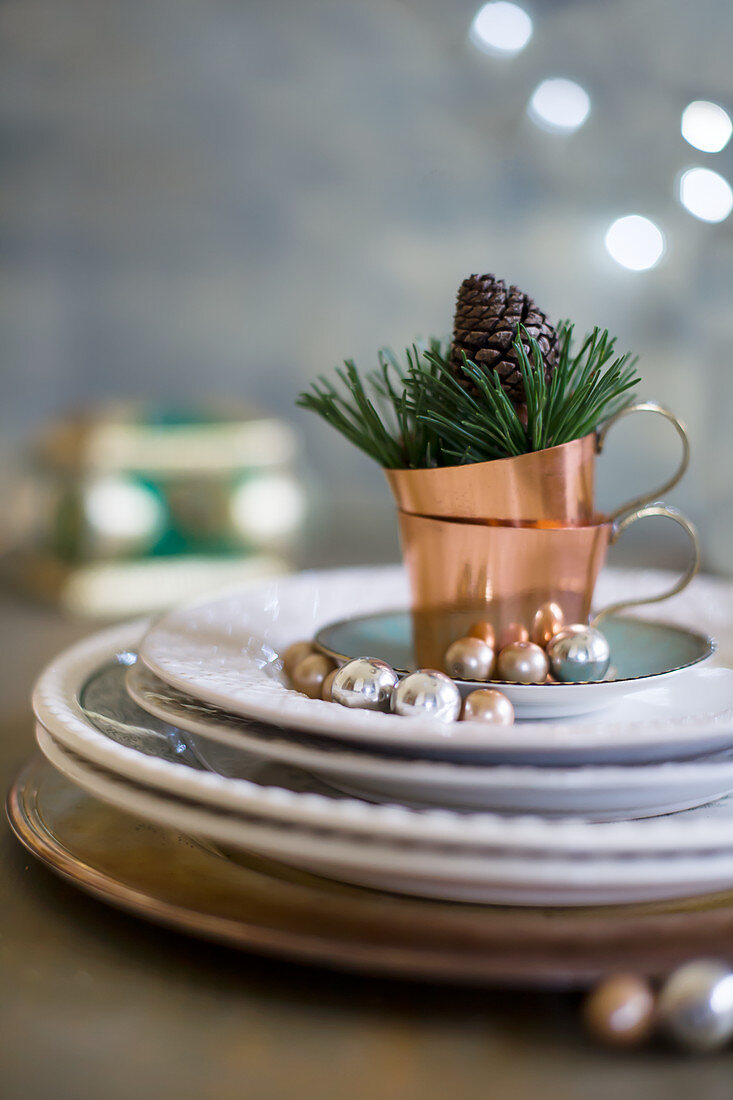 Plates and copper cups with Christmas decorations