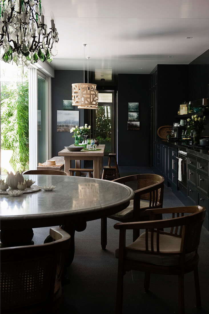 Runder Esstisch mit Stühlen in schwarzer Küche