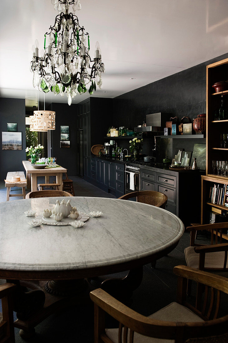 Runder Esstisch mit Stühlen in schwarzer Küche