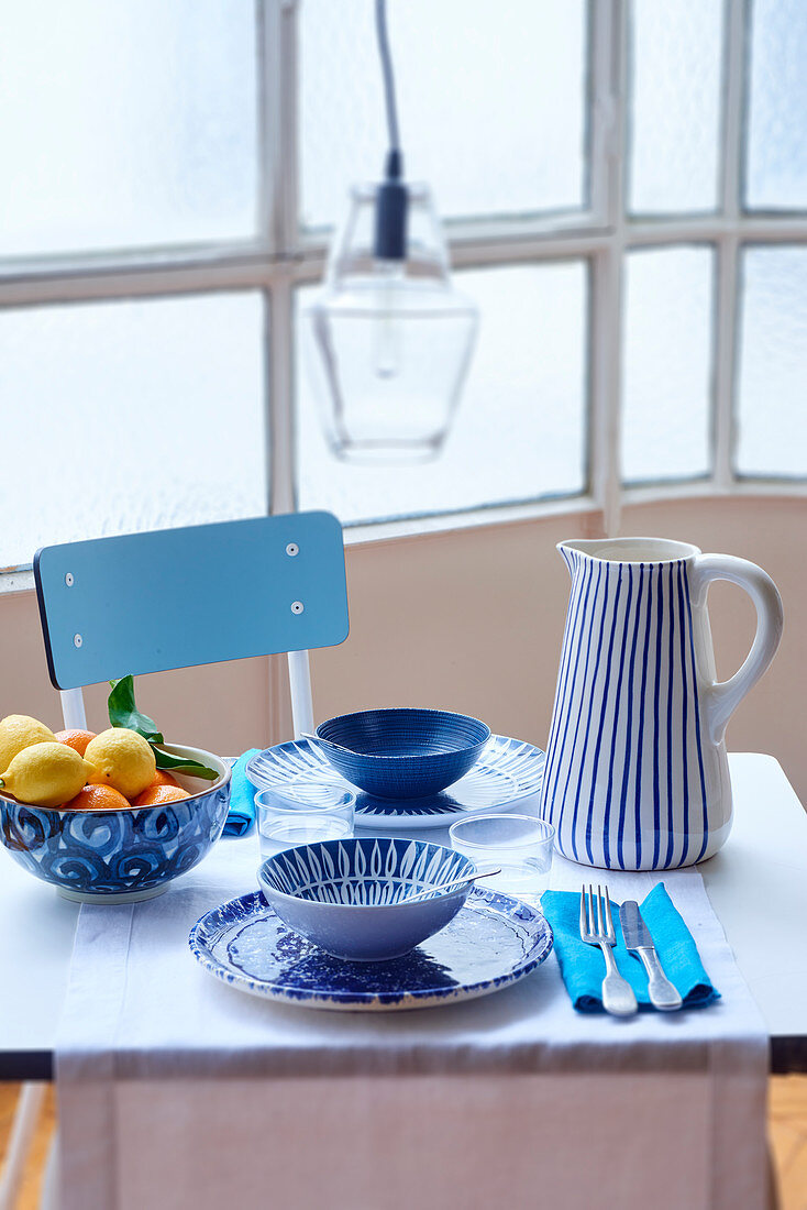 Table set for two with crockery in various blue patterns