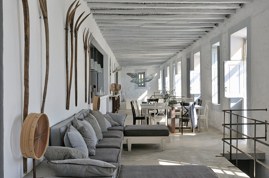 Open-plan interior in shades of grey with wooden ceiling beams and rustic accessories
