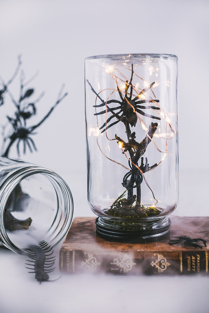 Halloween decorations handmade from jars, branches and toy spiders