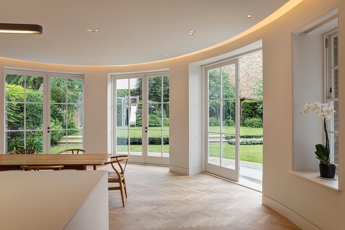 Dining area with curved wall and garden access