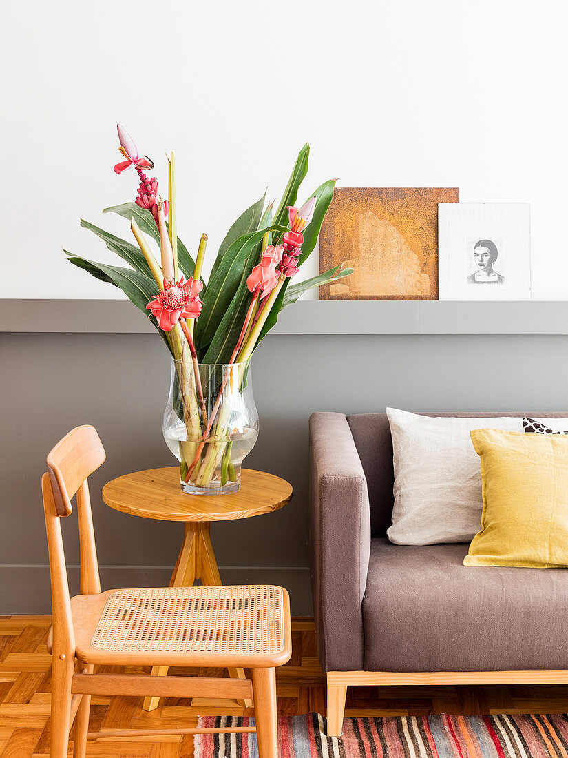 Flowers on side table and chair next to sofa