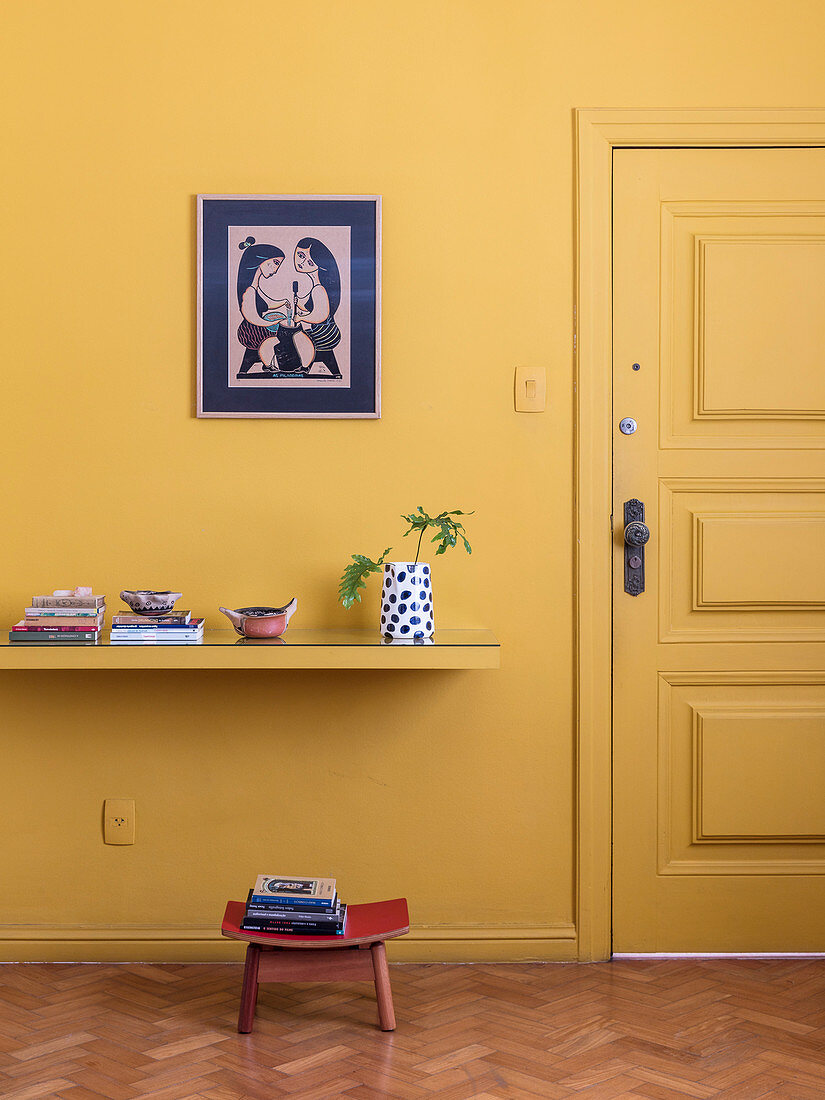 Yellow shelf on yellow wall next to yellow door