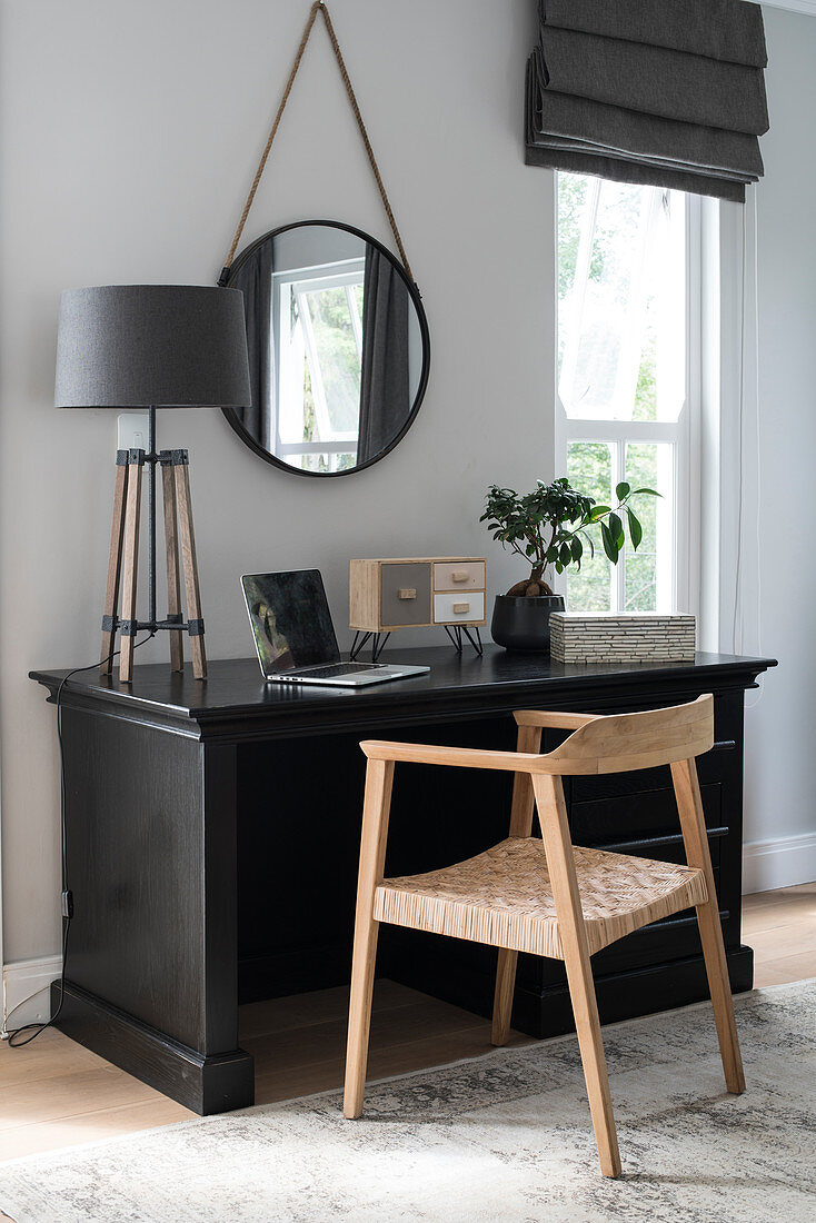 Schwarzer Schreibtisch umfunktioniert als Schminktisch mit rundem Spiegel und moderner Tischleuchte