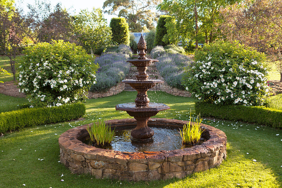 Three-tier, classic fountain in a landscaped garden