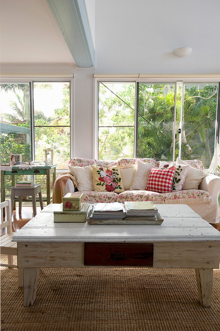 Shabby-chic coffee table in living room with glass wall