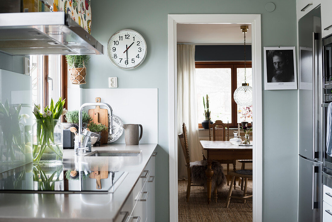 Kitchen with pale grey wall and view into dining room