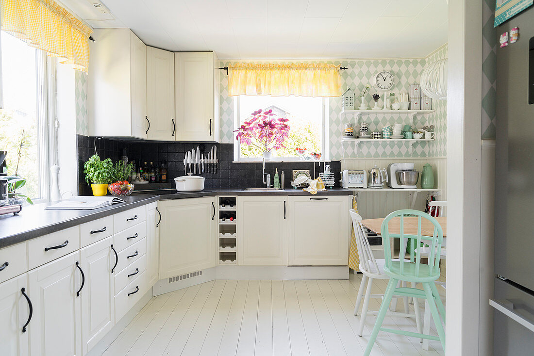 L-shaped kitchen counter in bright kitchen-dining room with white wooden floor