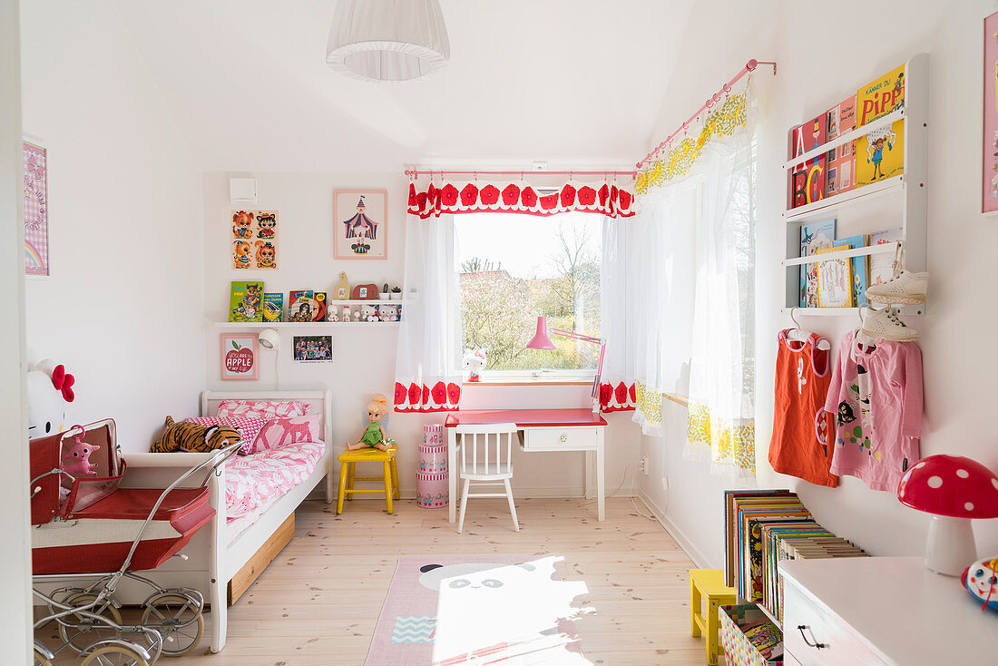 Bed, child's table, chair and shelves in girl's bedroom with pale wooden floor
