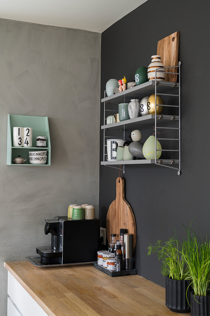 Wall-mounted shelves above coffee machine on wooden worksurface in kitchen