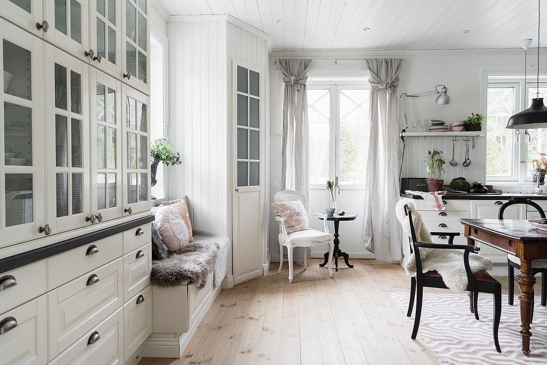 Weiße Wohnküche mit Sitzbank, Speisekammer und Essbereich