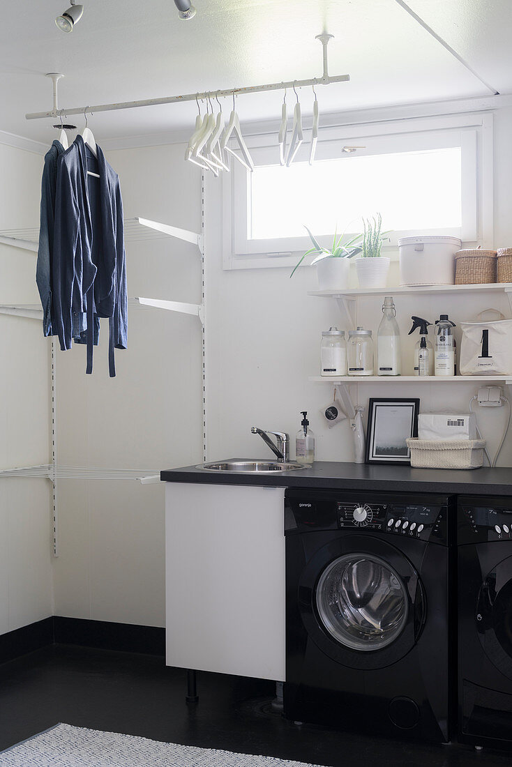 Washing machine and clothing hung from rack in laundry room