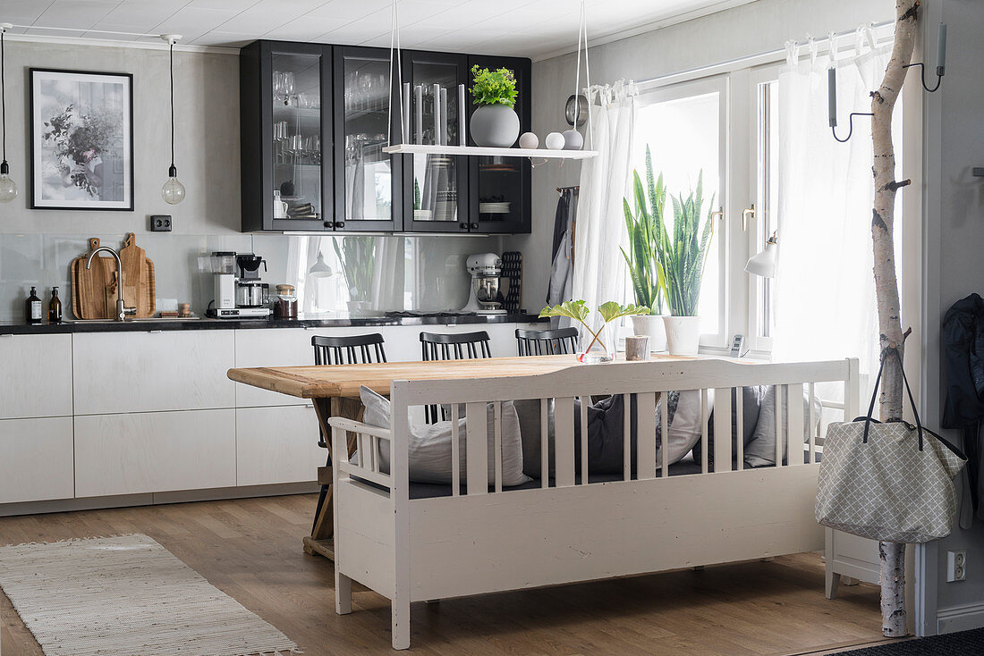 Weiße Küchenzeile mit schwarzer Arbeitsplatte und Essbereich in der Küche