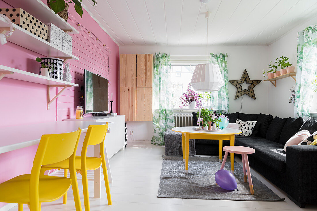 Pink wall in colourful living room with desk