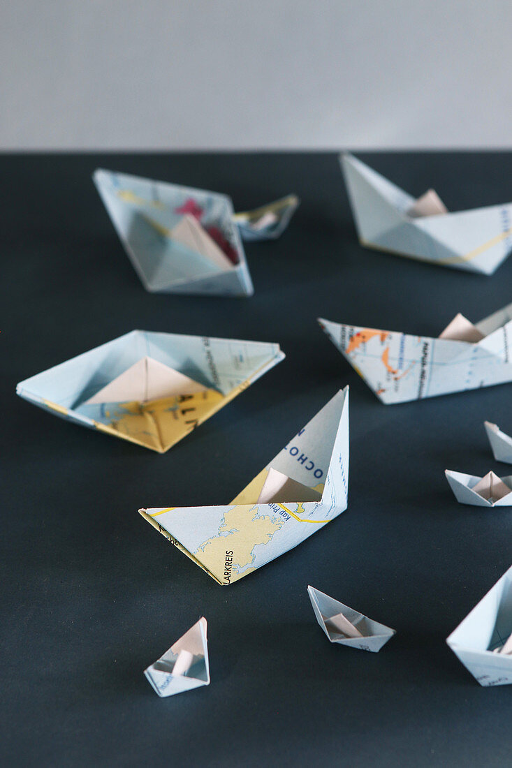 Small paper boats made from folded maps