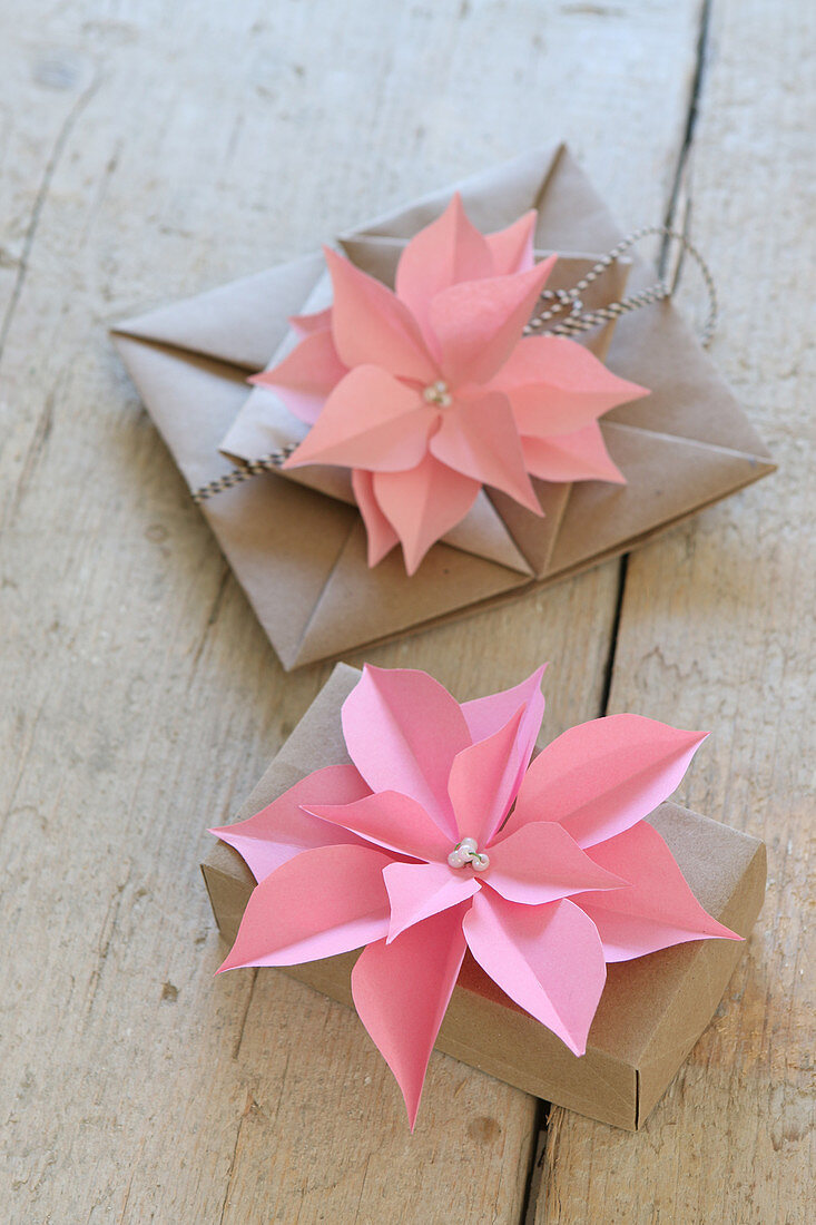 Pink paper flowers decorating wrapped gifts