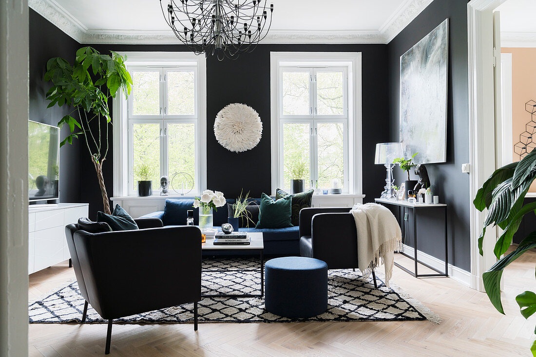 Elegantes Wohnzimmer mit schwarzen Wänden und mit schwarzen und weißen Accessoires