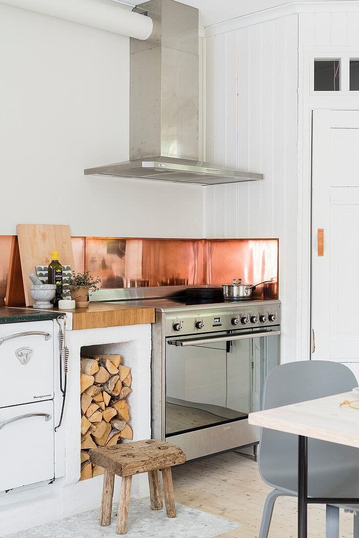 Sheet copper splashback in kitchen with wood-fired oven