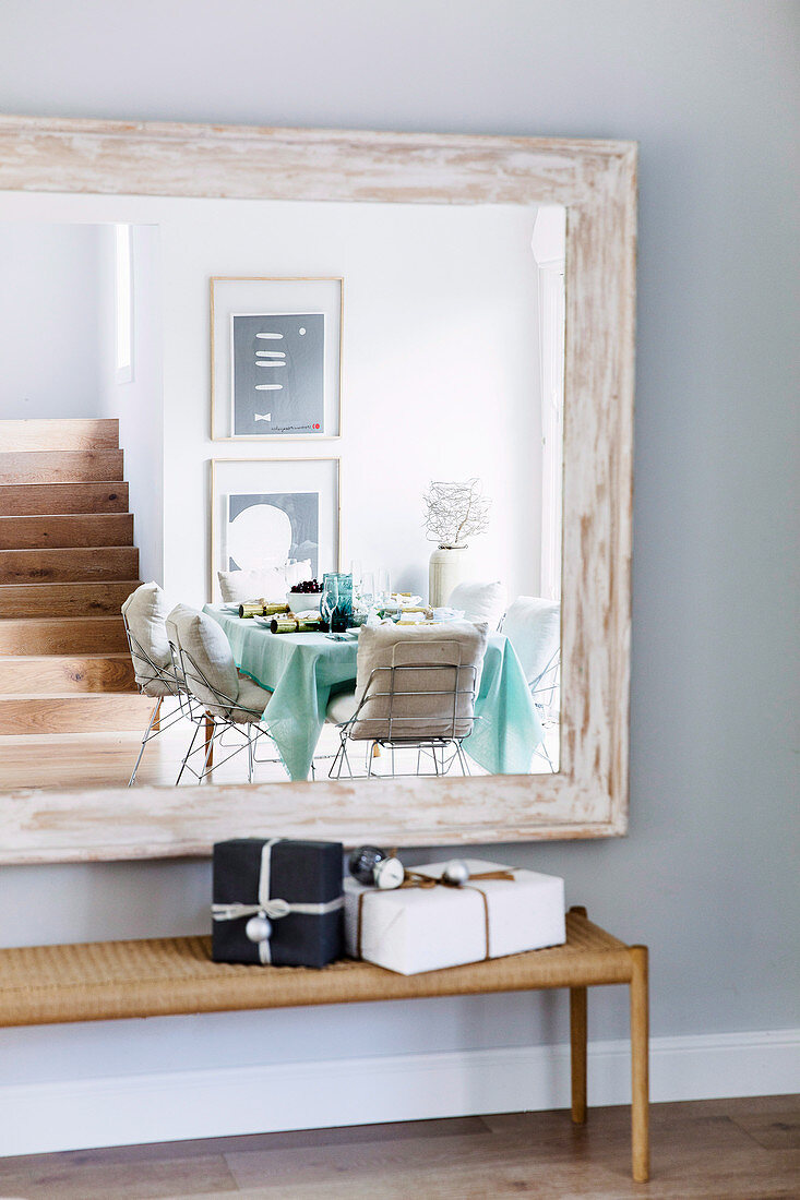 Modernes Esszimmer spiegelt sich im Wandspiegel mit Holzrahmen