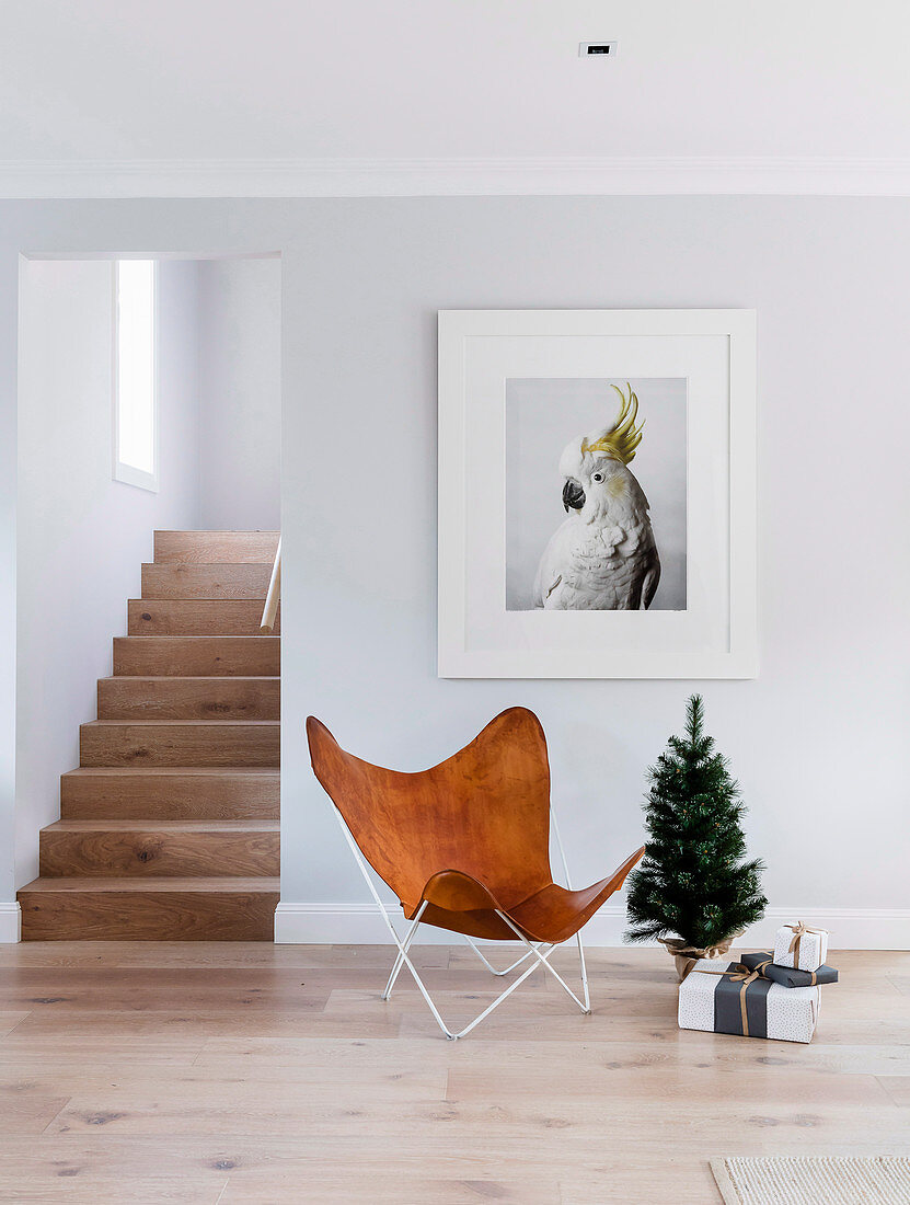 Designerstuhl aus Leder und Mini-Christbaum unterm Kakadu-Bild
