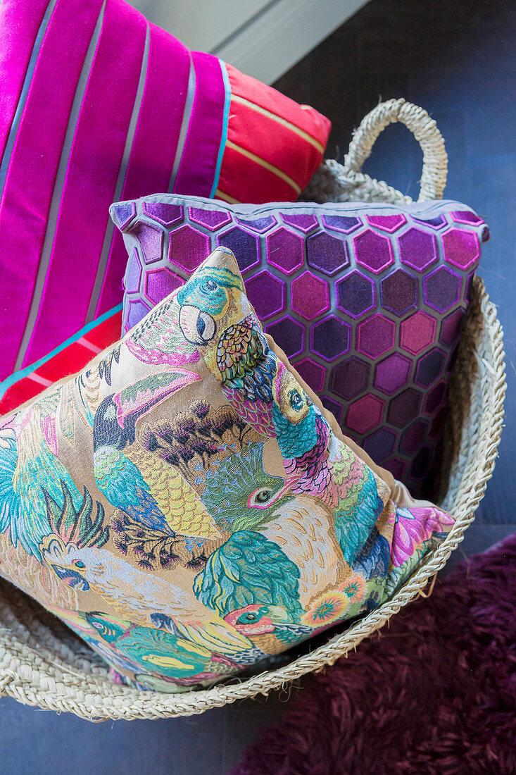 Cushions with patterns of birds, hexagons and stripes in basket