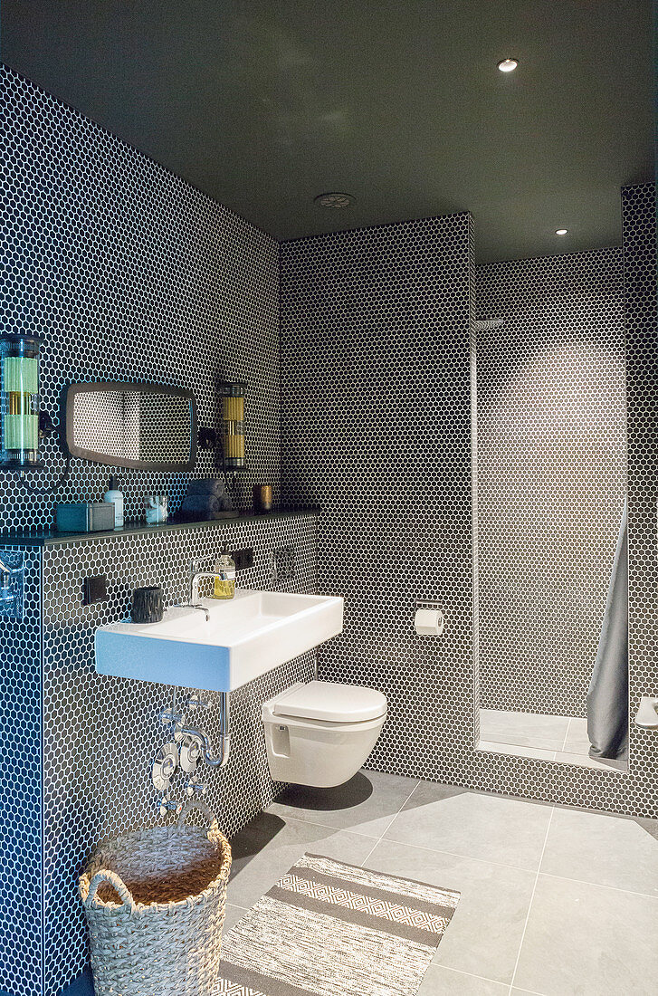 Runde, schwarze Mosaikfliesen im modernen Bad mit offener Dusche