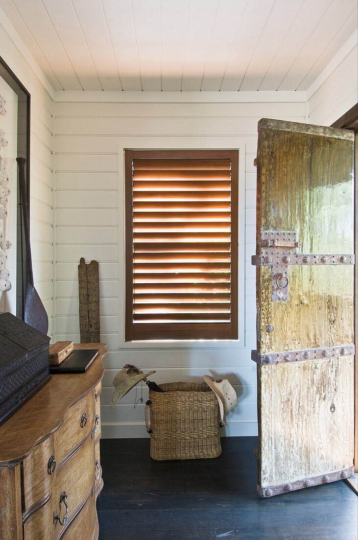 Rustic, open, wooden door with metal fittings in foyer