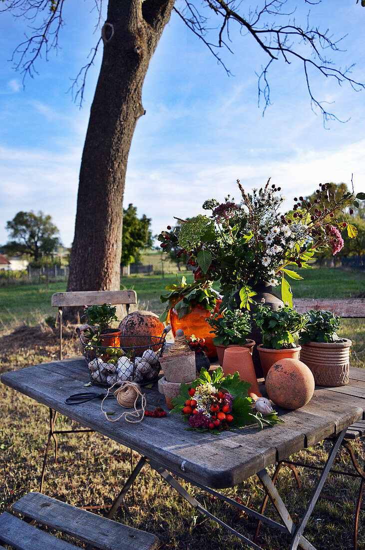 Herbstarrangement auf Tisch im Garten