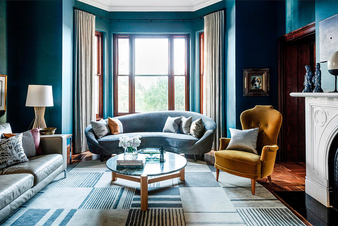 Elegant living room with dark blue walls and bay windows