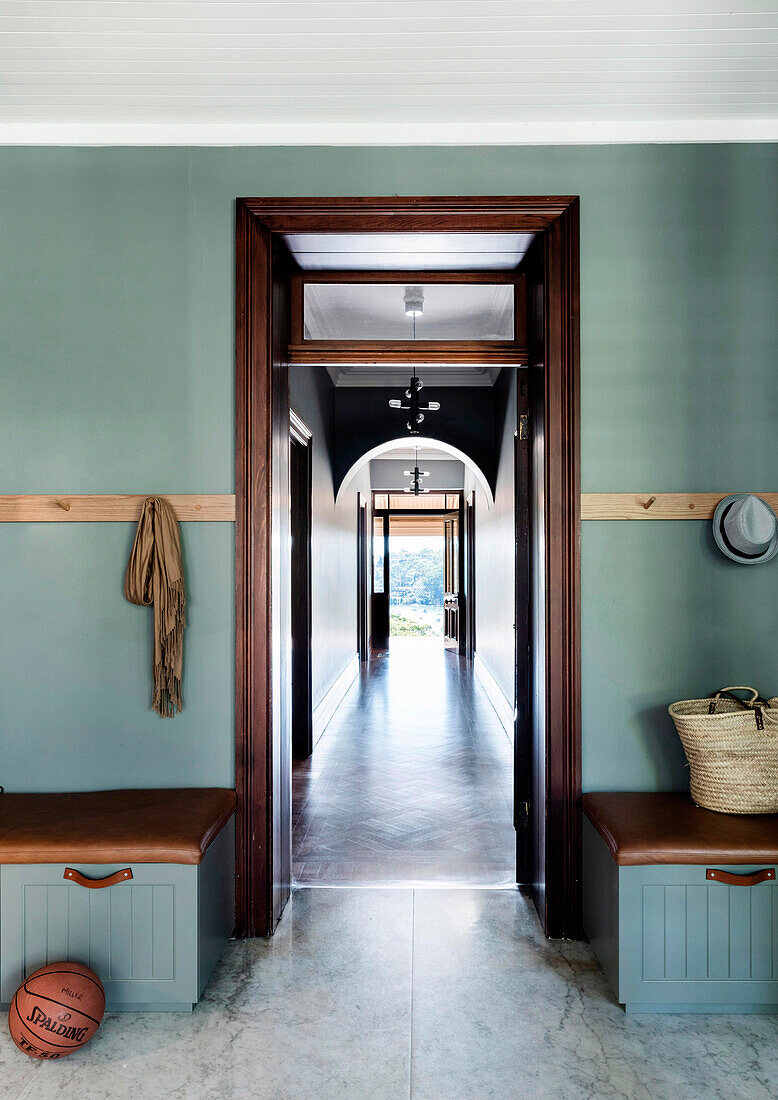 View from the cloakroom with petrol blue walls into the hallway