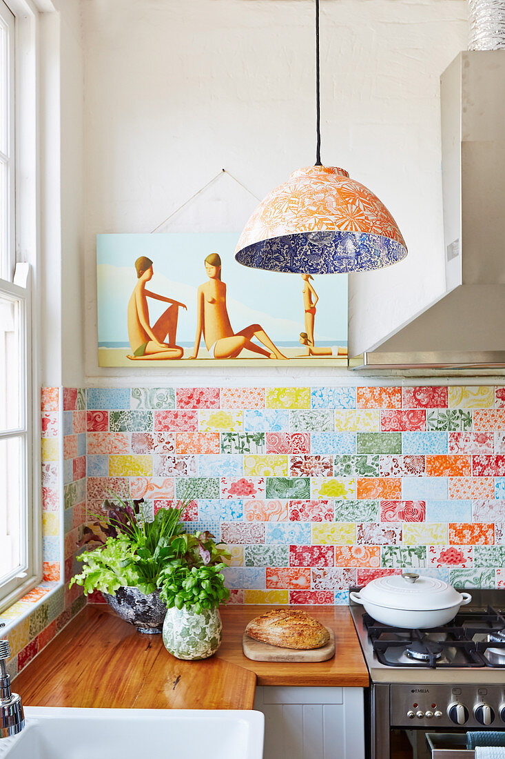 Fitted kitchen with wooden worktop and colorful wall tiles