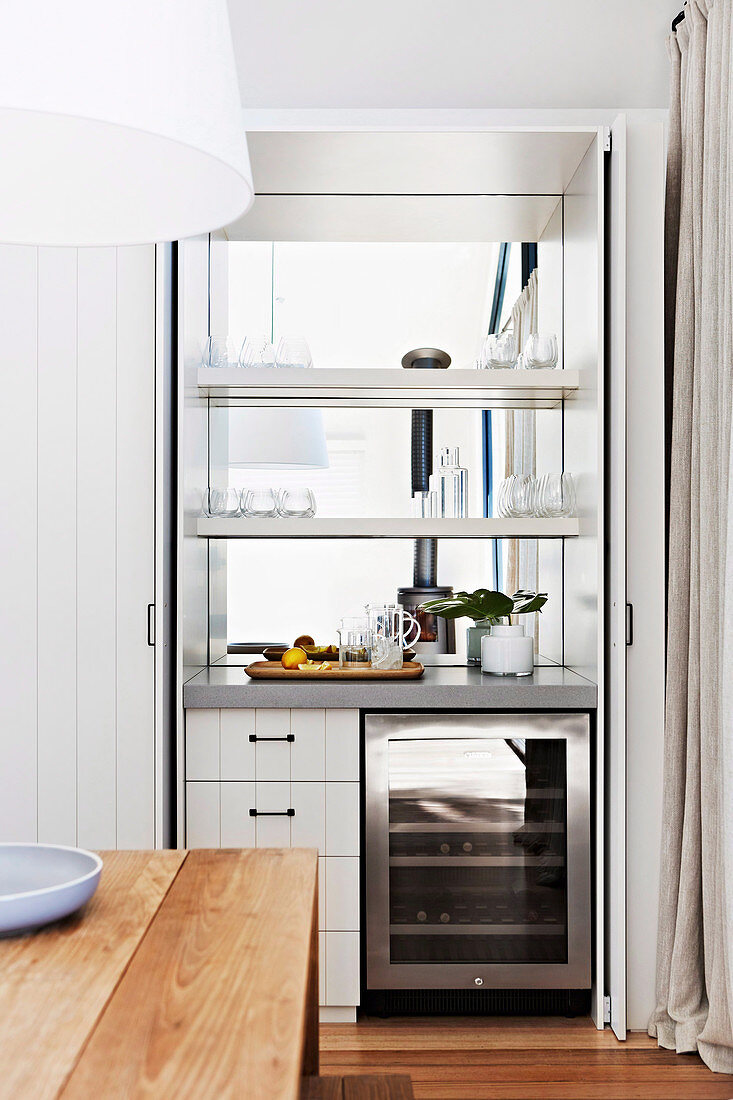 Hausbar mit Spiegelwand und Weinkühlschrank zwischen Küche und Esszimmer