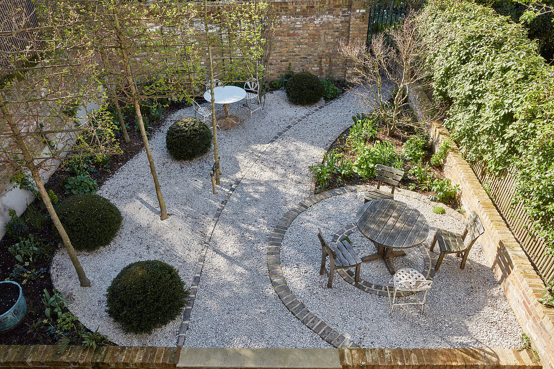 View down into courtyard with table and chairs on gravel terrace