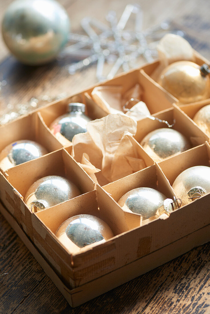 Old silver Christmas baubles in cardboard box