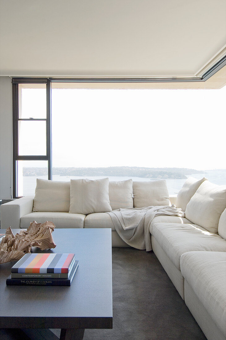 Cremefarbenes Sofa vor dem Eckfenster mit Panoramablick